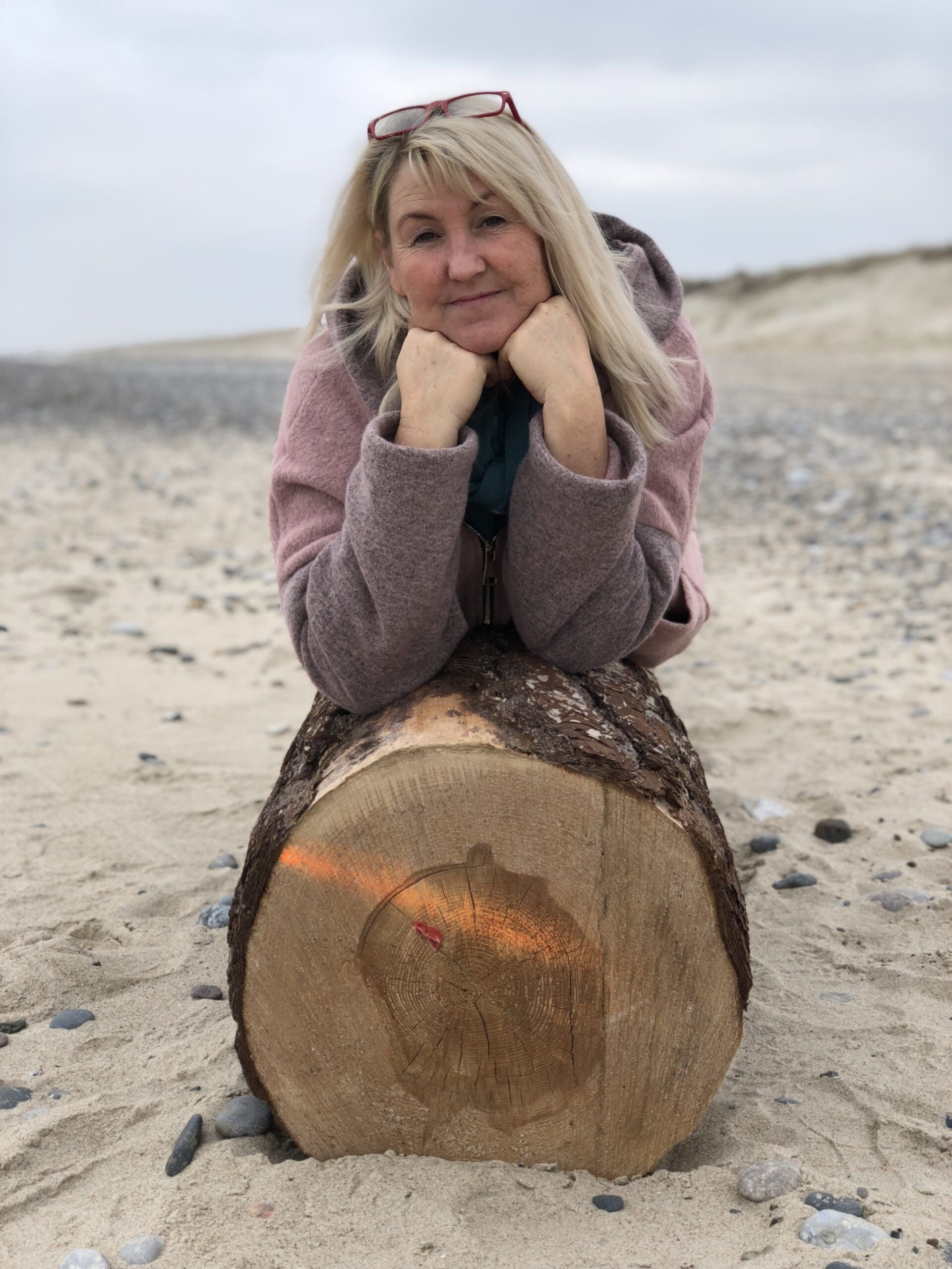 Forfatter Lotte Jensen på en pæl ved havet